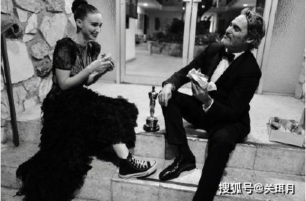 奥斯卡结束后,影帝华金 菲尼克斯跟未婚妻,坐台阶上吃汉堡